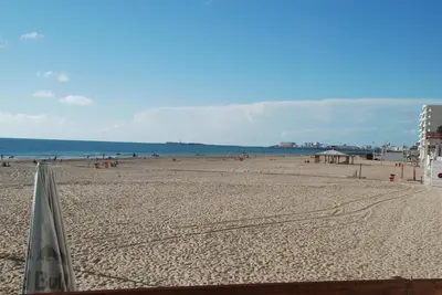 a beach with people and the ocean in the background at Brisas Estadio Playa Victoria in Cádiz