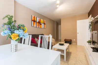 a living room with a vase of flowers on a table at Brisas Estadio Playa Victoria in Cádiz