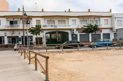 a building with cars parked in front of it at Apartamento La carraca in Chipiona
