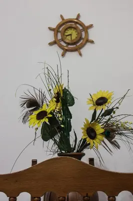 a clock on the wall above a vase of flowers at Apartamento La carraca in Chipiona