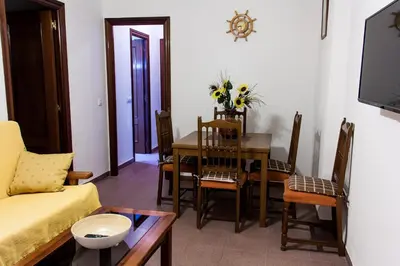 a living room with a dining room table and chairs at Apartamento La carraca in Chipiona
