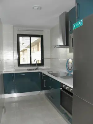 a kitchen with blue cabinets and a sink and a window at Apartamento en Jerez de la Frontera 2 in Jerez de la Frontera