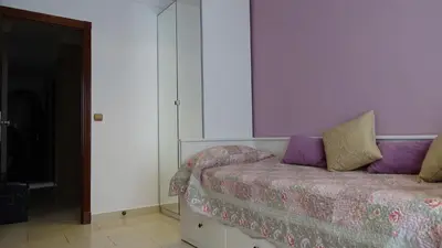 a bedroom with a bed with purple pillows on it at Cosy Caleta Apartment in Cádiz