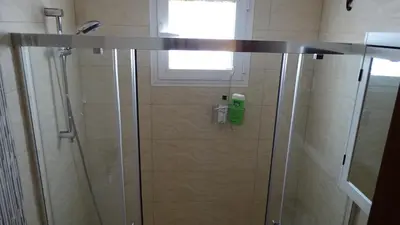 a shower with a glass door in a bathroom at Cosy Caleta Apartment in Cádiz
