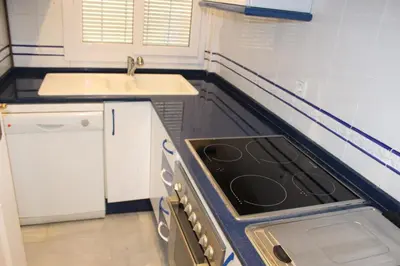 a kitchen with a stove top oven next to a sink at Apartamento Vespasiano in Chiclana de la Frontera