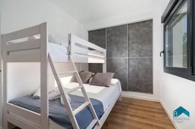 a bedroom with a bunk bed and a window at Villa La Barrosa in Chiclana de la Frontera