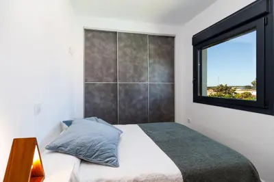 a bedroom with a bed and a window at Villa La Barrosa in Chiclana de la Frontera