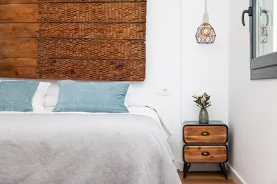 a bedroom with a bed and a wooden headboard at Villa La Barrosa in Chiclana de la Frontera