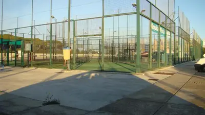 a glass building with a tennis court inside of it at Apartamento Marina el Puerto in El Puerto de Santa María