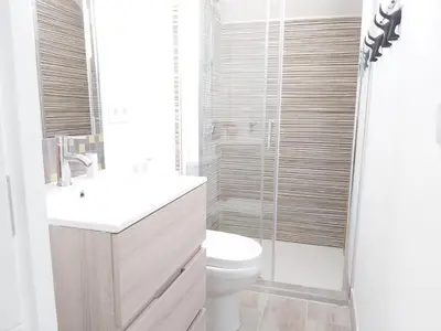 a bathroom with a toilet and a glass shower at Apartamento Marina el Puerto in El Puerto de Santa María