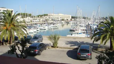a group of cars parked in a marina with boats at Apartamento Marina el Puerto in El Puerto de Santa María