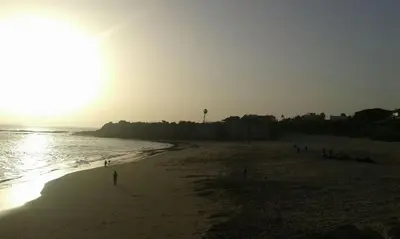 a beach with people on the sand and the ocean at Apartamento Marina el Puerto in El Puerto de Santa María