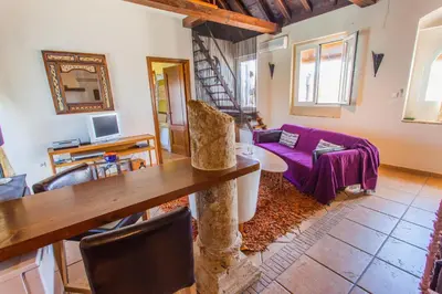 a living room with a table and a purple couch at Atico Sanlucar in Sanlúcar de Barrameda
