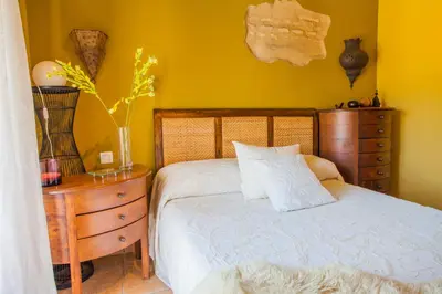 a bedroom with a bed and a wooden dresser with a bed sidx sidx sidx at Atico Sanlucar in Sanlúcar de Barrameda