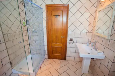a bathroom with a sink and a shower and a mirror at Atico Sanlucar in Sanlúcar de Barrameda