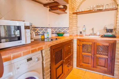 a kitchen with a washing machine and a microwave at Atico Sanlucar in Sanlúcar de Barrameda