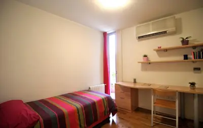 a bedroom with a desk and a bed with a striped blanket at La Casa del Limonero in El Puerto de Santa María