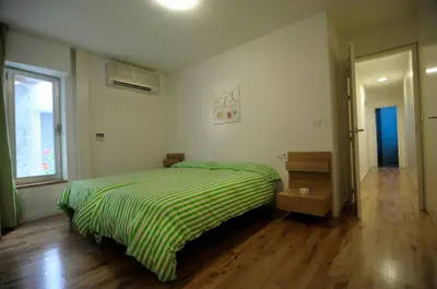 a bedroom with a bed with a green striped comforter at La Casa del Limonero in El Puerto de Santa María