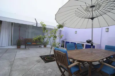 a wooden table with chairs and an umbrella at La Casa del Limonero in El Puerto de Santa María