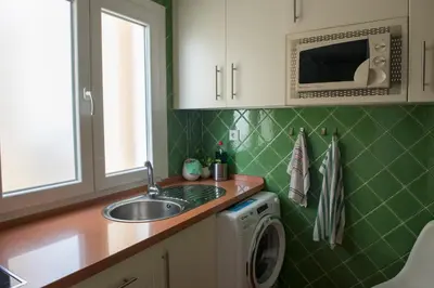 a kitchen with a sink and a washing machine at Casita Coqueta Free Parking in Cádiz