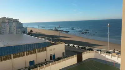 a view of a beach and a building and the ocean at Casita Coqueta Free Parking in Cádiz