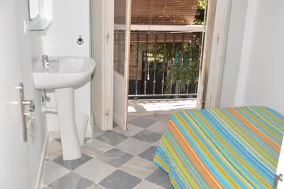 a bathroom with a sink and a door with a window at Pensión Las Cuatro Naciones in Cádiz