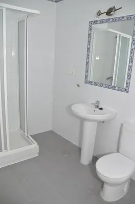 a bathroom with a toilet and a sink and a shower at Pensión Las Cuatro Naciones in Cádiz