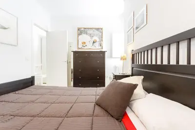 a bedroom with a large bed and a black dresser at El Mirador del CAMPANARIO by Cadiz4Rentals in Cádiz