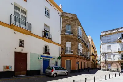 a car parked in a street between two buildings at El Mirador del CAMPANARIO by Cadiz4Rentals in Cádiz