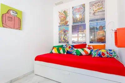 a room with a bed with posters on the wall at El Mirador del CAMPANARIO by Cadiz4Rentals in Cádiz