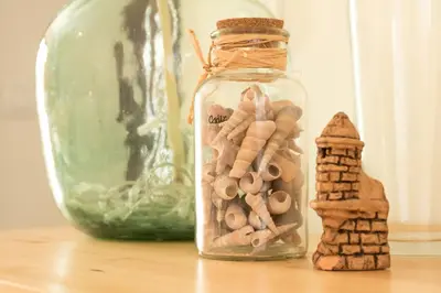 a glass jar filled with wood cutouts next to a gingerbread house at El Atico de las MARINAS free Parking by Cadiz4Rentals in Cádiz