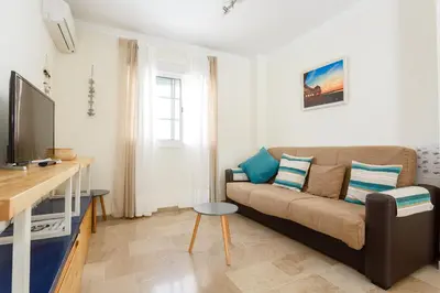 a living room with a couch and a tv at El Atico de las MARINAS free Parking by Cadiz4Rentals in Cádiz