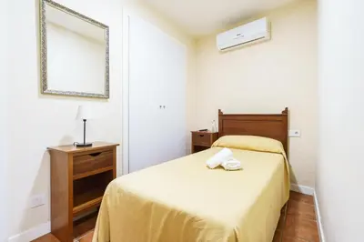 a small bedroom with a bed and a mirror at Hotel Carlos V Jerez by Vivere Stays in Jerez de la Frontera
