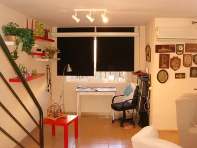 a living room with a window with a black window shade at Chalet Pto Sta Maria, SOLO FAMILIAS in El Puerto de Santa María