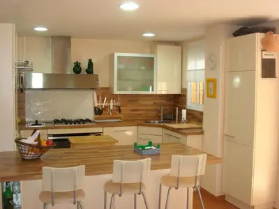 a kitchen with white cabinets and white stools at Chalet Pto Sta Maria, SOLO FAMILIAS in El Puerto de Santa María