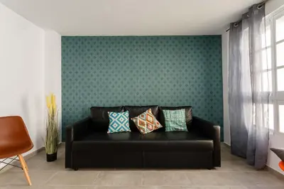 a black couch in a room with a green wall at PASACALLES Home by Cadiz4Rentals in Cádiz