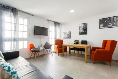 a living room with orange chairs and a table at PASACALLES Home by Cadiz4Rentals in Cádiz