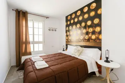a bedroom with a large bed with a wooden headboard at PASACALLES Home by Cadiz4Rentals in Cádiz
