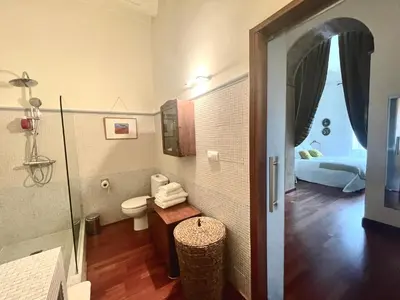 a bathroom with a toilet and a room with a bed at Eva Recommends Porvenir Apartment in Jerez de la Frontera