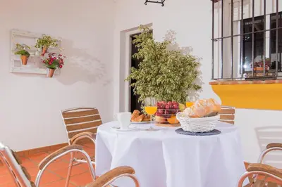 a white table with a basket of food and drinks at El Mirador de Bellavista in Conil de la Frontera