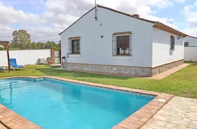 a white house with a swimming pool in front of it at Casa con piscina 92 in Conil de la Frontera
