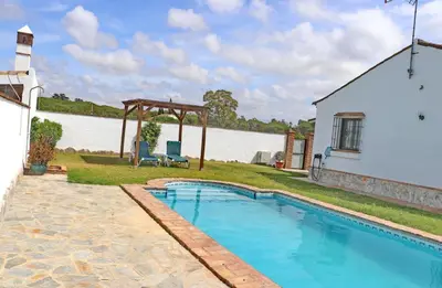 a swimming pool with a gazebo next to a house at Casa con piscina 92 in Conil de la Frontera