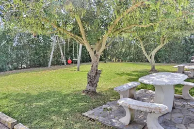a picnic table and two benches in a park at Casa con piscina 92 in Conil de la Frontera