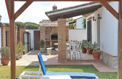 a house with a patio with a table and chairs at Casa con piscina 92 in Conil de la Frontera