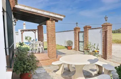 a patio with a table and a table and chairs at Casa con piscina 92 in Conil de la Frontera