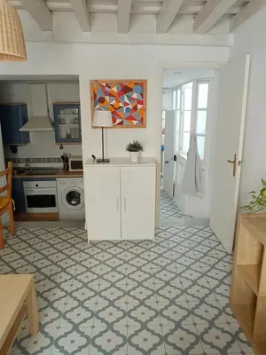 a kitchen with white cabinets and a floor with a table at Sagasta Apartments in Cádiz