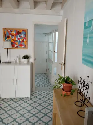 a living room with a table and a painting on the wall at Sagasta Apartments in Cádiz