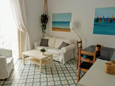 a living room with a white couch and a table at Sagasta Apartments in Cádiz