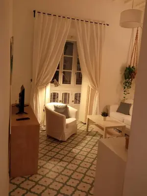 a living room with a white couch and a window at Sagasta Apartments in Cádiz