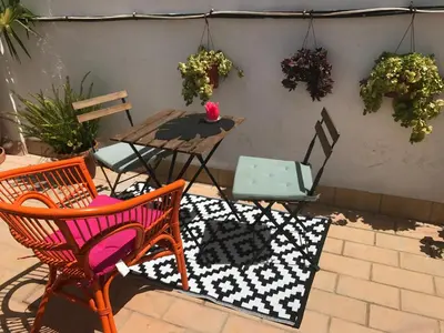 a patio with chairs and a table and a table and chairs at Ático Falla in Cádiz